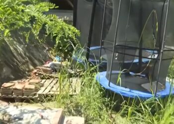Patio cubierto con un trampolín y pilas de ladrillos.