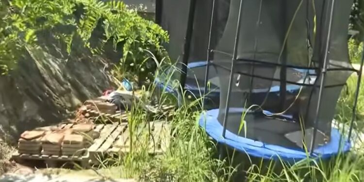 Patio cubierto con un trampolín y pilas de ladrillos.