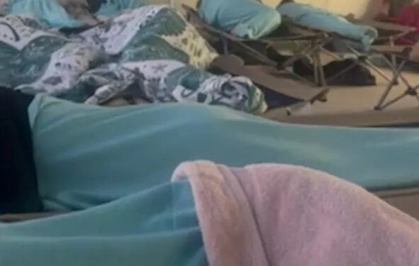 Pasajeros durmiendo en cunas en una habitación.