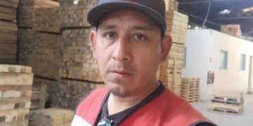 Hombre en un chaleco de seguridad rojo de pie en un asombro.