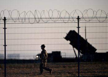 Soldado pasando junto a los sistemas de defensa aérea de Patriot en un centro militar.