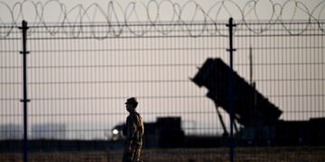Soldado pasando junto a los sistemas de defensa aérea de Patriot en un centro militar.