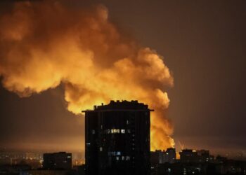 Explosión cerca de un edificio de la ciudad por la noche.