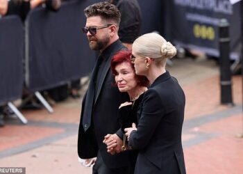 Jack y Kelly sosteniendo a Sharon por los brazos mientras camina