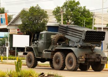 Cambodiano camión militar con lanzacohetes alejando.