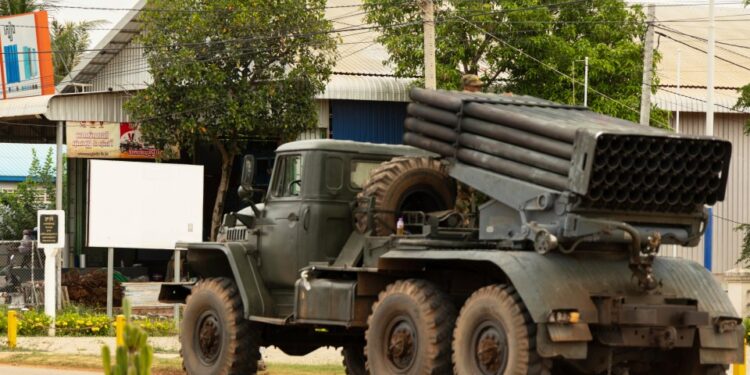 Cambodiano camión militar con lanzacohetes alejando.