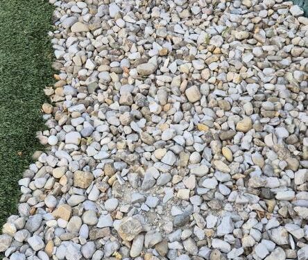 Pelota de golf escondida entre rocas.