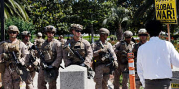 Las tropas nacionales de Gaurd marchan a través de una zona residencial