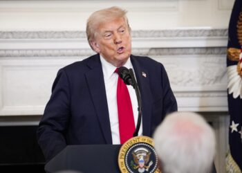 El presidente Trump hablando en un podio.