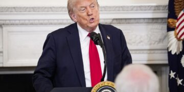 El presidente Trump hablando en un podio.