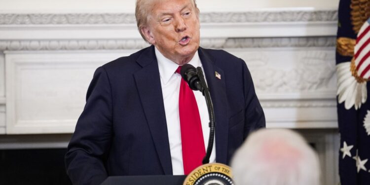 El presidente Trump hablando en un podio.