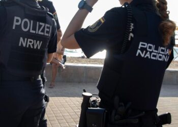 Oficiales de policía alemanes y españoles patrullando una playa.