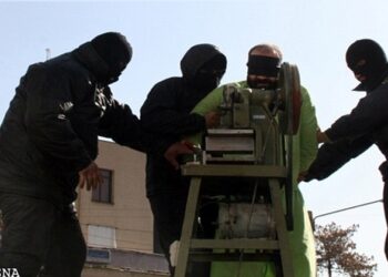 Los dedos de un hombre con los ojos vendados son amputados por una sierra circular.