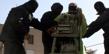 Los dedos de un hombre con los ojos vendados son amputados por una sierra circular.