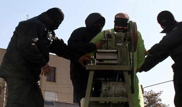 Los dedos de un hombre con los ojos vendados son amputados por una sierra circular.