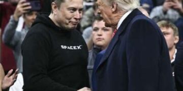 Tesla y el CEO de SpaceX, Elon Musk, y el presidente de los Estados Unidos, Donald Trump, se dan la mano mientras asisten a la competencia de lucha libre de la NCAA masculina en el Wells Fargo Center en Filadelfia, Pensilvania, el 22 de marzo de 2025.