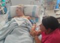 Mujer hospitalizada sosteniendo la mano de su madre.