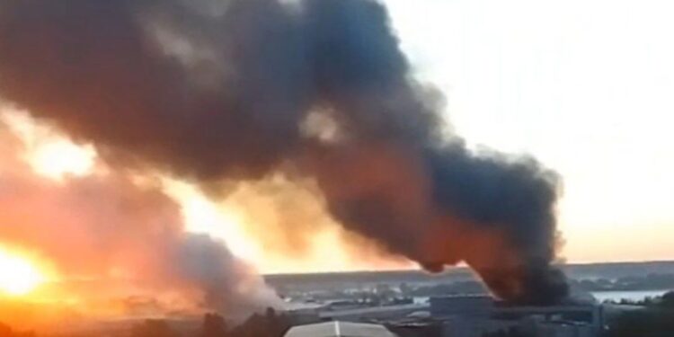 Gran incendio y humo que ondulación de un edificio.