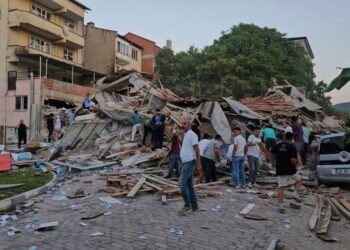 Las personas eliminan los escombros de un edificio colapsado después de un terremoto.