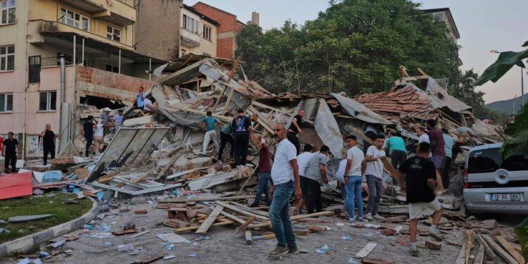 Las personas eliminan los escombros de un edificio colapsado después de un terremoto.