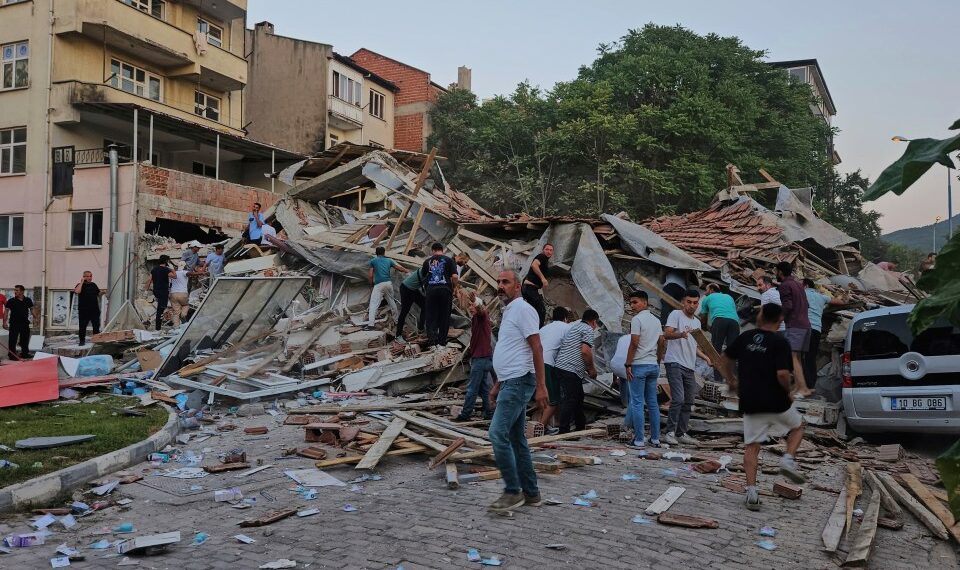 Las personas eliminan los escombros de un edificio colapsado después de un terremoto.