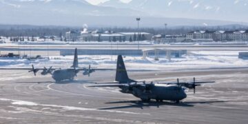 Dos aviones C-130 Hércules de la Fuerza Aérea de los Estados Unidos en un asfalto nevado.