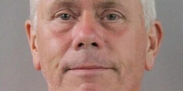 Mugshot de un hombre con un mono naranja.