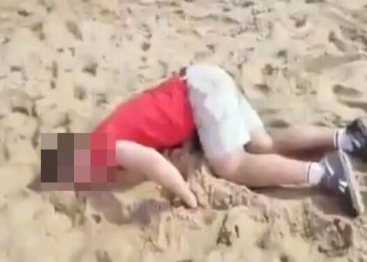 Turista drogado acostado en una playa.