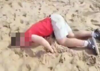 Turista drogado acostado en una playa.