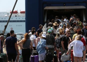 Pasajeros que esperan en una terminal de ferry con equipaje.