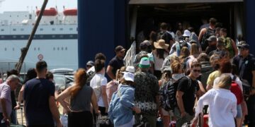 Pasajeros que esperan en una terminal de ferry con equipaje.