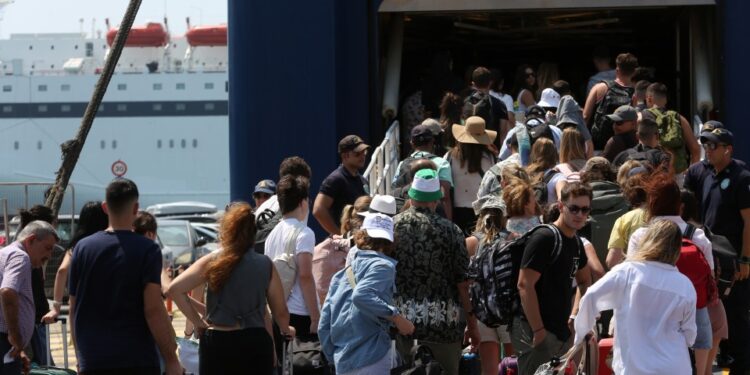 Pasajeros que esperan en una terminal de ferry con equipaje.