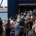 Pasajeros que esperan en una terminal de ferry con equipaje.