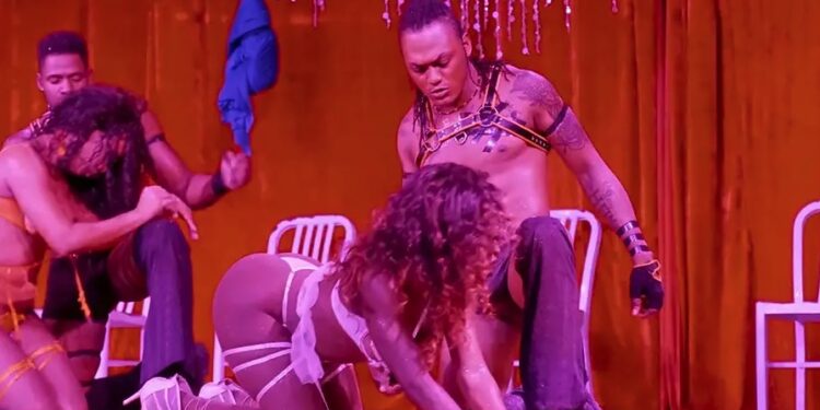 Artistas en varias etapas de desnudez en el escenario.