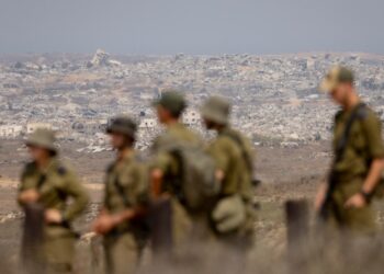 Soldados israelíes que observan edificios destruidos en la Franja de Gaza.