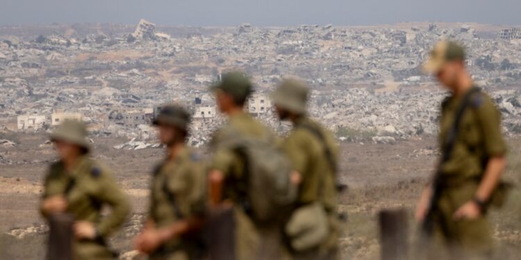 Soldados israelíes que observan edificios destruidos en la Franja de Gaza.