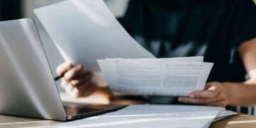 Una mujer joven mira páginas de facturas