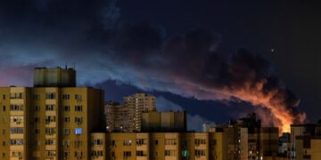 El humo se eleva sobre los edificios de apartamentos de Kyiv por la noche después de ataques de misiles rusos.