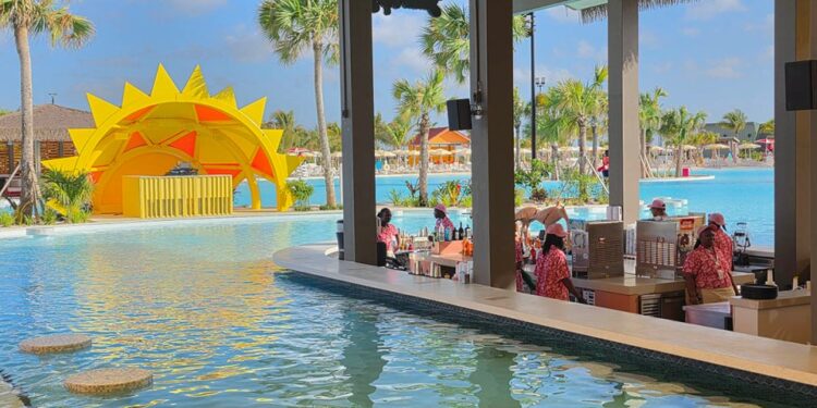 Barra de natación en un complejo con una gran piscina y una estructura de sol amarillo.