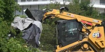 Los trabajadores de la ciudad de DC desmantelan las carpas y eliminan las pertenencias personales durante un barrido de un campamento para personas sin hogar en el vecindario inferior de Foggy en Washington, DC, el 14 de agosto de 2025.