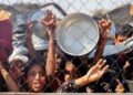 Los palestinos, en su mayoría niños, presionan para recibir una comida caliente en una cocina benéfica en el área de Mawasi de Khan Yunis en el Southern Gaza Strip el 22 de julio de 2025.