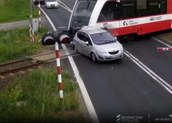El automóvil se estrella por la barrera ferroviaria y es atropellado en tren.