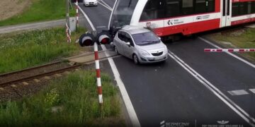 El automóvil se estrella por la barrera ferroviaria y es atropellado en tren.