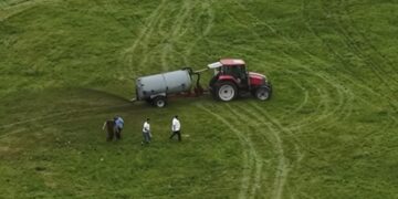 Tractor que extiende el estiércol en un campo.