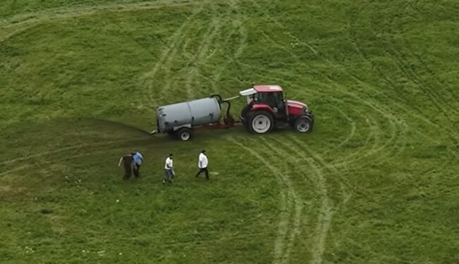 Tractor que extiende el estiércol en un campo.