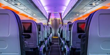 Aisillo de cabina de pasajeros de avión por la noche.