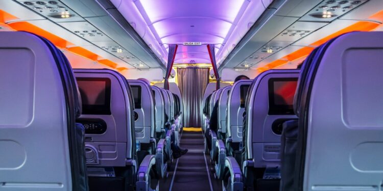 Aisillo de cabina de pasajeros de avión por la noche.