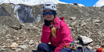 Mujer descansando durante una subida de montaña.