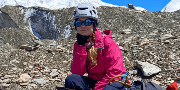 Mujer descansando durante una subida de montaña.