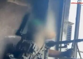 Imagen borrosa de un francotirador apuntando un rifle.